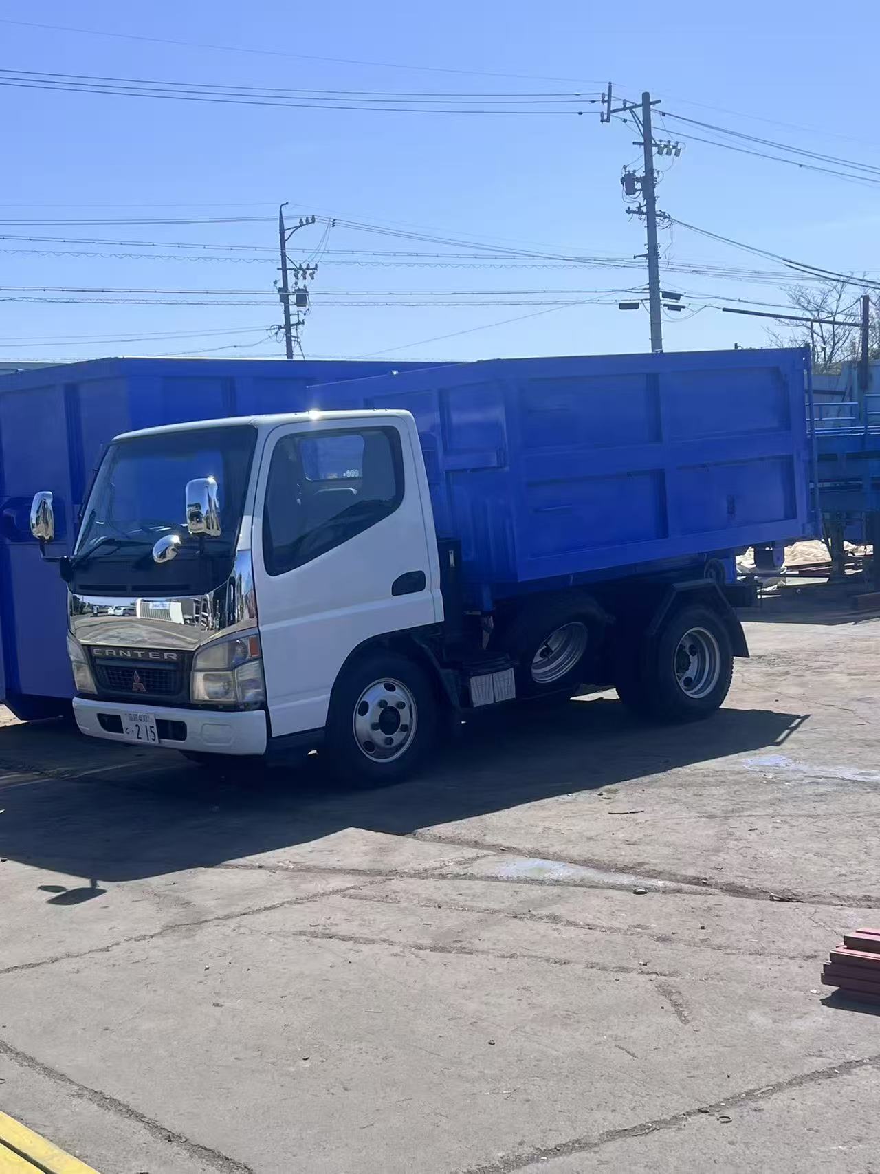 青色アームロールコンテナを積載した小型車両